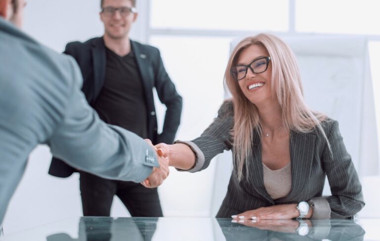 Happy businesswoman shaking hands with a businessman