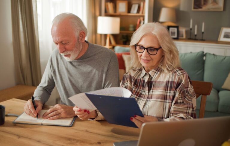 Happy senior couple looking at financial paperwork.