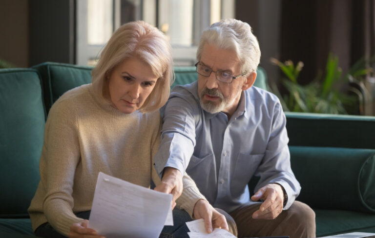 Serious senior couple looking at financial paperwork