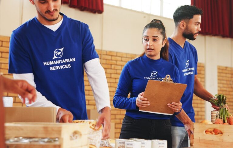 Volunteers wearing “humanitarian services” t-shirts while packing boxes of donations