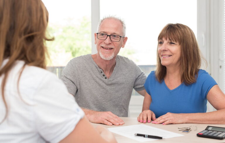 Relaxed, happy middle-aged couple talking to their financial planner