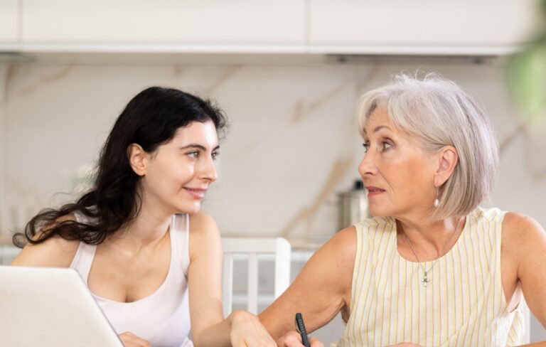 Mother and daughter looking at a laptop and paperwork together