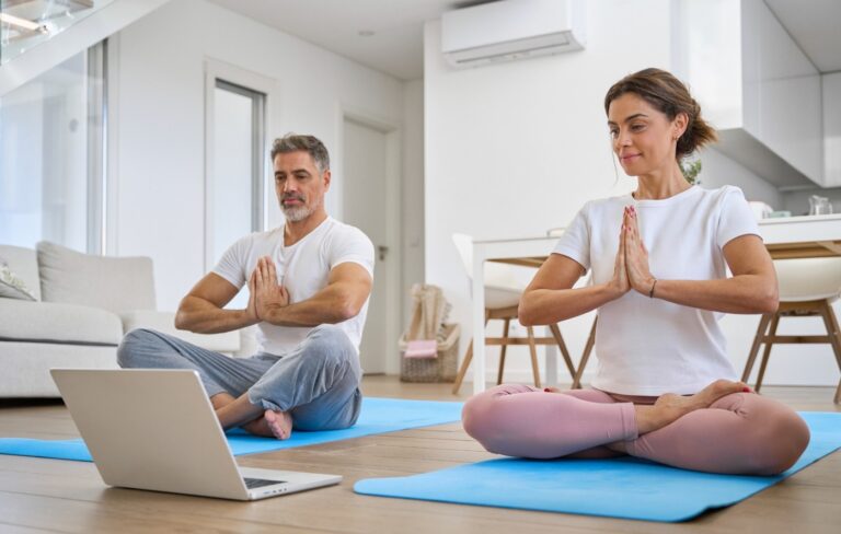 Middle-aged couple doing yoga at home
