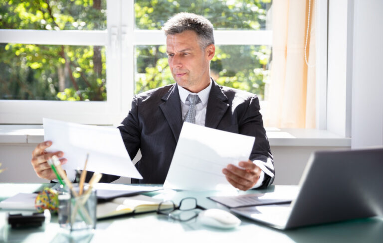 Middle-aged businessman at a desk looking at paperwork